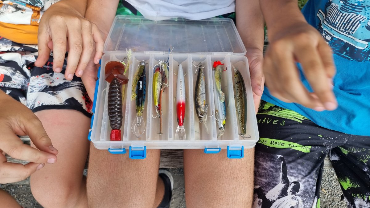 Group inspecting the hard lure box on a bench